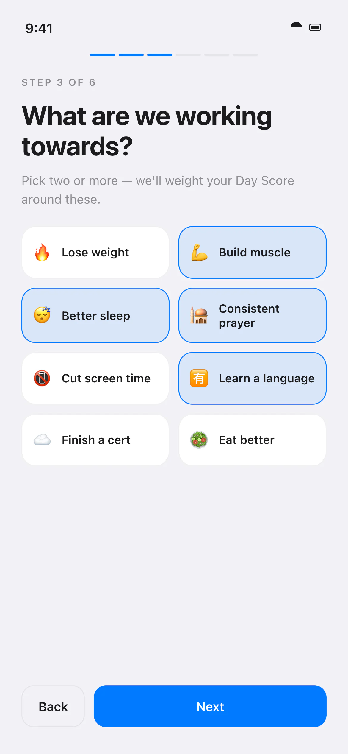 Yaumi onboarding step in the Apple Clean theme asking what the user is working towards, with eight goal chips such as Build muscle, Better sleep and Consistent prayer, four of them selected, and Back and Next buttons